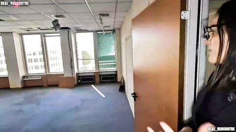 Sexy Asian woman with glasses stands by office door in tight black top teasing viewers