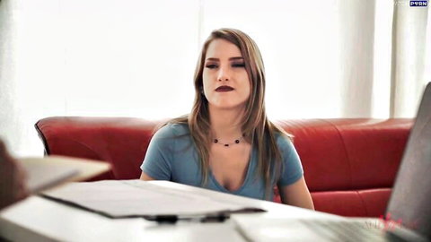 Young skinny blonde with small tits in low-cut blue top sits pensively on red couch in therapy office
