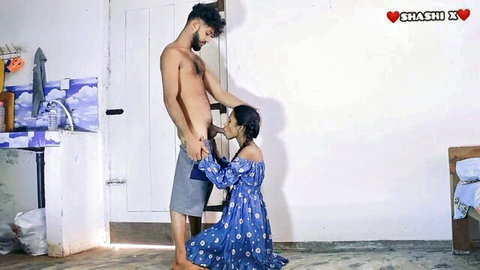 Skinny Indian brunette kneels in blue floral dress sucking huge erect cock homemade blowjob