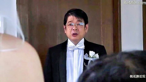 Japanese man in tuxedo speaking at wedding with veil in foreground