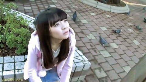Cute Japanese student in pink hoodie kneeling with pigeons in park, JAV thumbnail