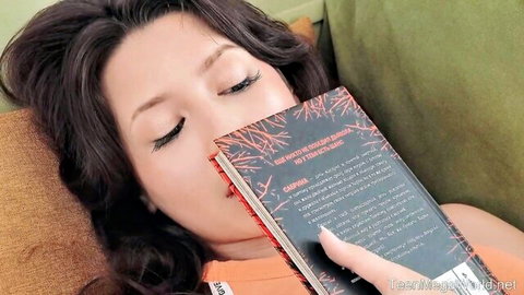 Seductive Asian beauty with long dark hair reading book teasingly