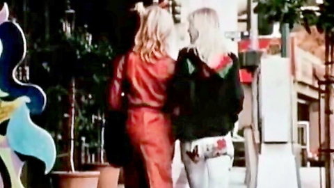 Two sexy blondes walking away on street in tight red dress and white pants vintage style