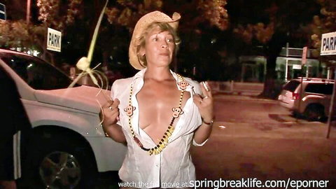 Blonde woman in open white shirt with beads necklace showing cleavage at Florida Fantasy Fest