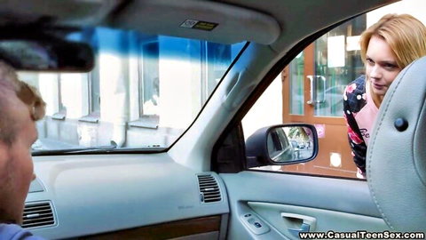 Blonde teen in floral top leans into car door talking to bald guy in public pickup tease