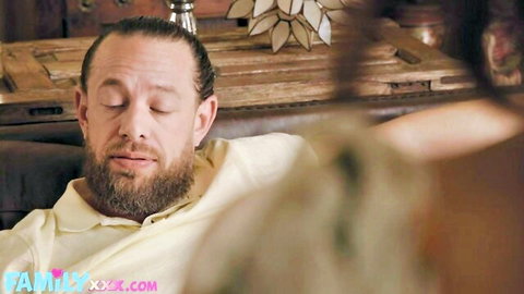 Bearded stepbrother squints in pleasure on couch with blurred teen stepsister in front