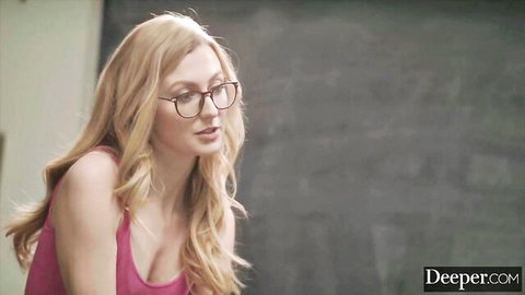 Blonde babe in glasses teases deep cleavage in pink low-cut top against chalkboard