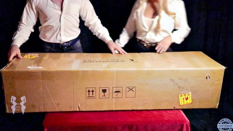 Blonde couple poses with giant sex toy box in teasing adult promo thumbnail