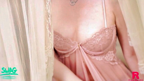 Sexy Asian beauty in pink lace lingerie teasing with deep cleavage