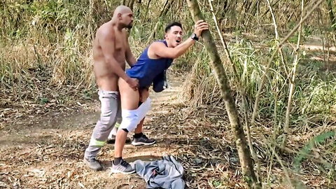 Muscular bald man anal fucking fit guy in blue tank top against tree in woods