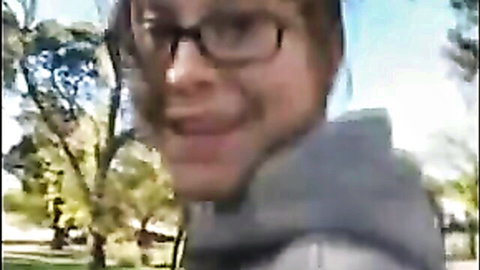 Nerdy college girl with glasses smiles in hoodie outdoors