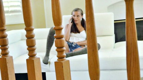 Skinny young teen with small tits in braless white top and tight denim shorts talks on phone on couch