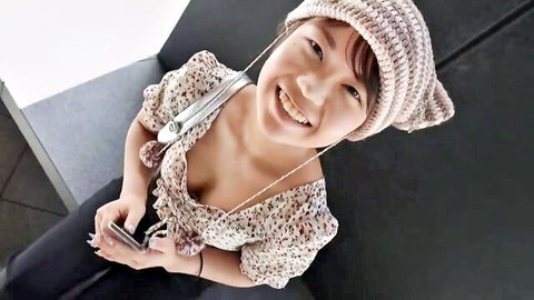 Cute Asian girl in beanie smiling with cleavage in off-shoulder top