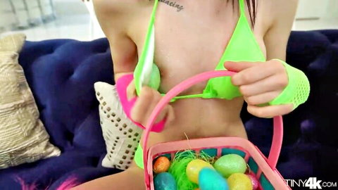 Audrey Grace in neon green bikini holding Easter basket, teasing petite body