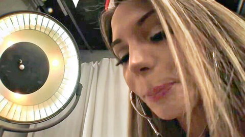 Blonde Brazilian nurse with hoop earrings smiling seductively in hot threesome preview