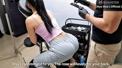 Myanmar woman in pink top and sweats on table with gloved masseur