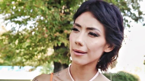 Veronica Leal seductive smile in orange top outdoors, short black hair