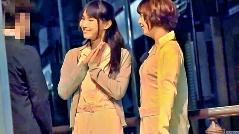 Two smiling Japanese women in beige and yellow cardigans clapping hands on balcony