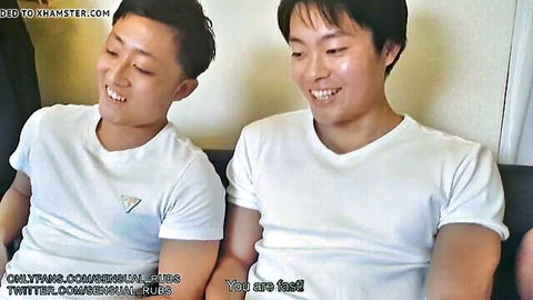 Two smiling Japanese boys in white t-shirts, caught in gay threesome fun