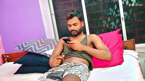 Handsome Indian man lounging on bed in green tank top and shorts, teasing amateur vibe