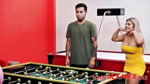 Curvy blonde Latina in tight yellow dress flaunts big tits and ass by foosball table with tattooed guy