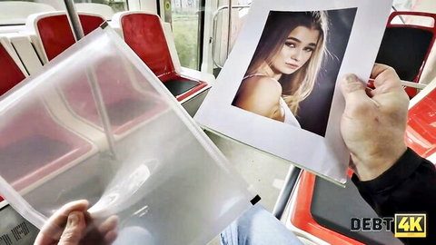 Hand holds photo of seductive skinny blonde teen with small tits and long hair showing cleavage