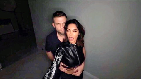 Vittoria Divine in black leather top embraced by man from behind, MILF OnlyFans teaser