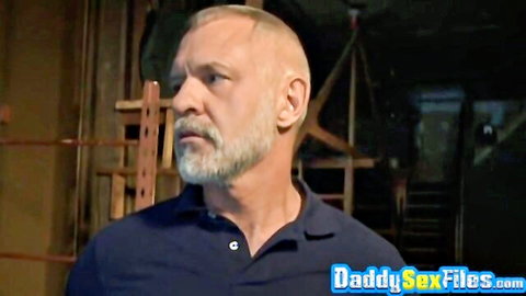 Muscular silver fox DILF daddy with beard in tight polo shirt stares intensely