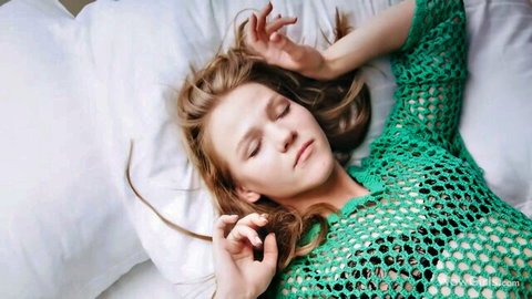 Diana Heaven relaxing seductively in green crochet top on bed