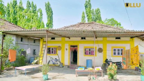 Rustic Indian village house with yellow walls, tiled roof, courtyard beds, bikes and plants in Ullu episode