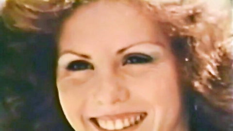 Vintage blonde with big curls smiling, classic porn thumbnail featuring natural tits