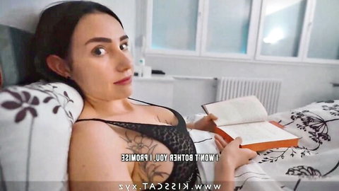 Brunette MILF with huge tits in black lace bra lounging on bed reading book