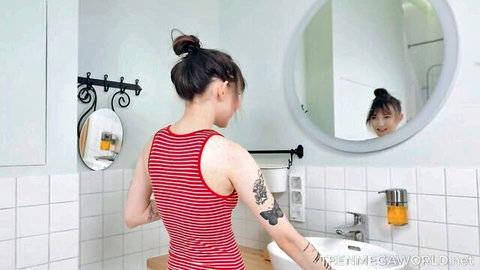 Tattooed Asian babe in tight red striped tank top bending over bathroom sink showing sideboob and curves