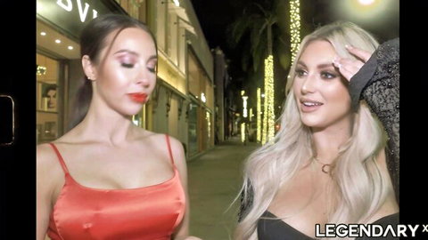 Kayley Gunner in red dress with blonde friend on lit night street