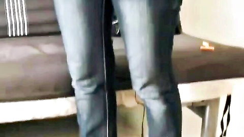 Lyka in tight blue jeans teasing on couch edge