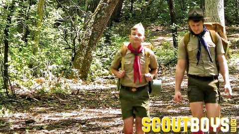 Logan Cross and Cole Blue in scout uniforms hiking outdoors, gay twink adventure