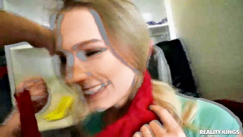 Kyler Quinn smiles with blonde hair gripped, red scarf around neck in intimate scene