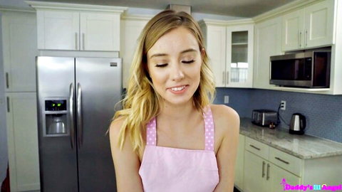Haley Reed blonde in pink apron, smiling in kitchen tease