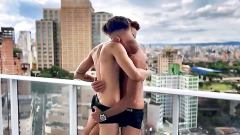 Brazilian tattooed hunks embracing intimately on balcony