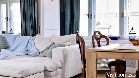 Subil Arch and Amalia Davis relaxing on sofa in elegant living room