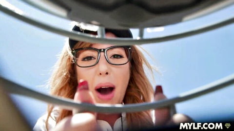 Lauren Phillips in glasses peeks through bars with open mouth