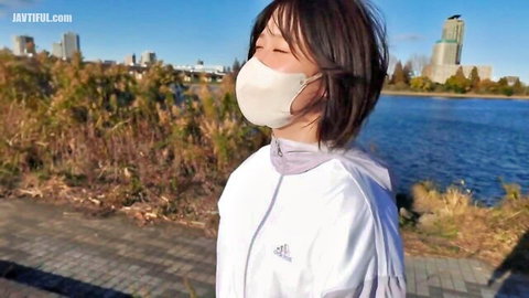 Asian woman in white mask and jacket posing outdoors by lake, JAV style