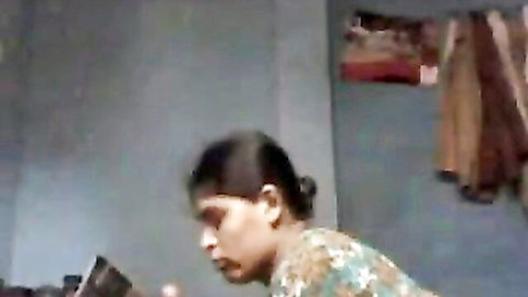 Petite South Asian woman in colorful sari leaning forward viewing phone teasingly