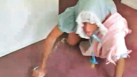 Adult baby man in bonnet bib and pacifier crawls on all fours in ABDL fetish play