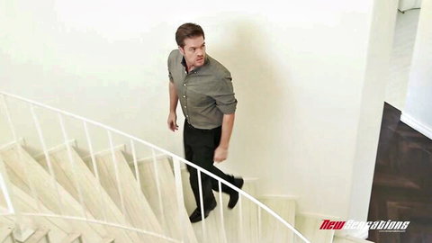 Ryan Ryder descending spiral stairs in casual shirt and pants