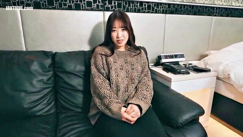 Asian woman in chunky sweater lounging on couch, lazy to aroused vibe