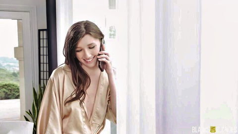 Brunette in open satin robe smiling on phone showing deep cleavage