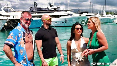 Muscular men and sexy women in revealing outfits pose together on yacht marina dock