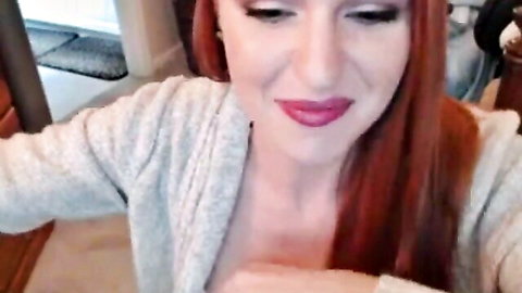 Redhead Goddess Christina in open gray cardigan, seductive smile and teasing gaze