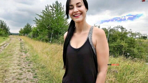 Smiling brunette teen in low-cut tank top showing cleavage outdoors